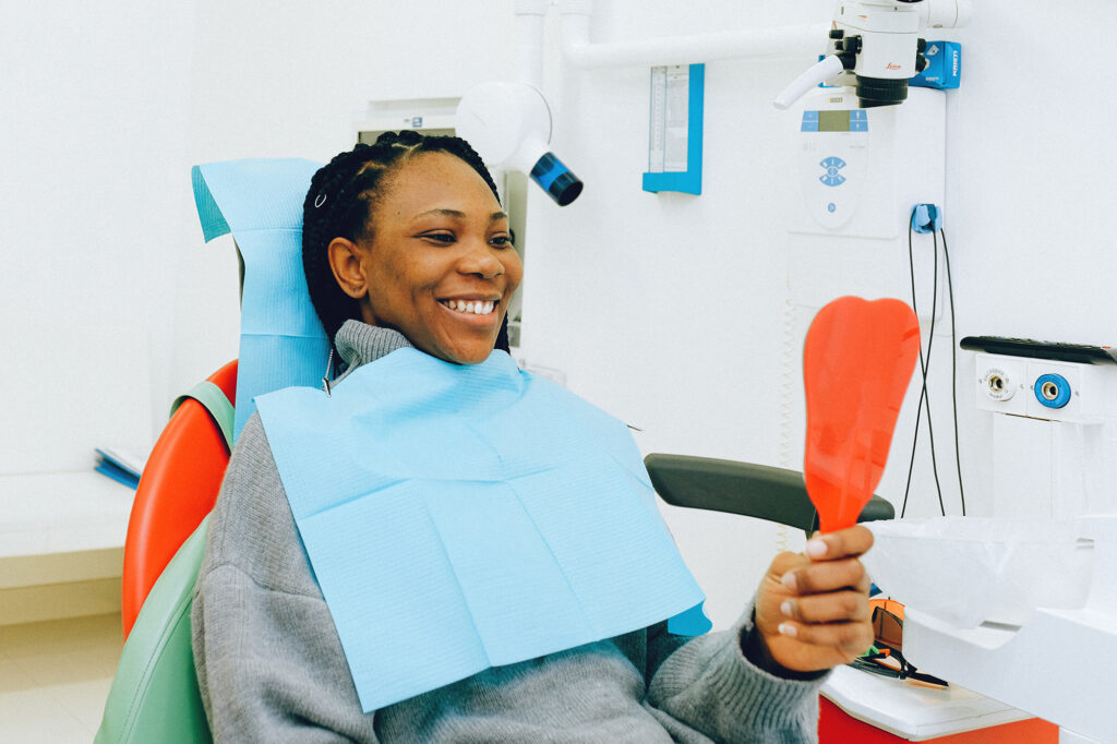 Person smiling confidently after in-person dentist teeth whitening appointment.